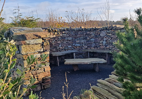 Photograph of the a stone seating area looking towards North Barrule